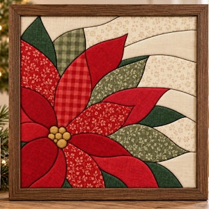 May include: A square framed fabric art piece featuring a central poinsettia flower. The petals are crafted from various red and green patterned textiles, including floral and gingham prints. A cluster of small yellow fabric circles forms the center.