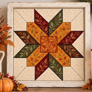 May include: A square wall art piece featuring a central star pattern composed of fabric-like segments in shades of deep red, forest green, and golden yellow, all decorated with a delicate leaf and berry print, encased in a distressed white frame.