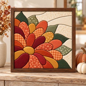 May include: A square wall art piece featuring a fabric-covered floral design in shades of orange, red, yellow, and green, encased in a dark wood frame. The petals display various textures, including solid colors, gingham checks, and small floral prints.