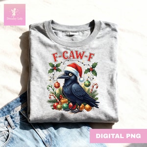 Könnte beinhalten: Hellgraues Rundhals-T-Shirt mit einem Cartoon-Raben, der einen Weihnachtsmannhut trägt. Der Rabe ist von Weihnachtsdekorationen und dem Text "F-CAW-F" umgeben. Die Worte "DIGITAL PNG" stehen unten.