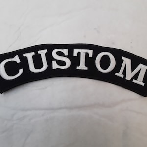 May include: Black and white embroidered patch with the word "CUSTOM" in white lettering.