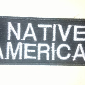 May include: Black fabric patch with white embroidered text that reads "NATIVE AMERICAN".