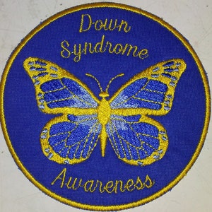 May include: A blue circular patch with a gold embroidered butterfly and the text "Down Syndrome Awareness".