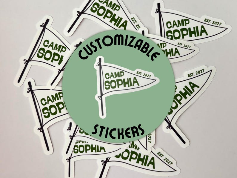 May include: A collection of white flag-shaped stickers with the text "CAMP SOPHIA" in a dark green font. The stickers also include the text "EST. 2027". A green circle in the center reads "CUSTOMIZABLE STICKERS".