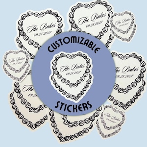May include: A selection of heart-shaped stickers featuring a cake design and the text "The Bakes 09.28.2027". A blue circle in the centre reads "CUSTOMIZABLE STICKERS". The stickers are white with black detailing.