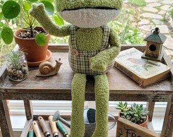Gran rana de peluche caprichosa con overol a cuadros, con peso, de 23,5 pulgadas, ideal para colocar en estantes.
