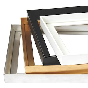 May include: A selection of picture frames in different colours. The frames are silver, gold, black, and white. The rectangular frames have a simple, modern design. The frames are stacked on top of each other.
