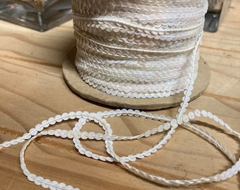 Cinta de lentejuelas blancas brillantes. Se vende por metro. Se corta a pedido.