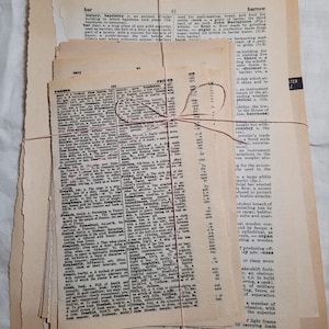 Könnte beinhalten: Ein Stapel alter Wörterbuchseiten, mit Schnur gebunden. Die Seiten sind vergilbt und zeigen verschiedene Wörter und Definitionen. Das Bündel ist ein Vintage-Artikel, ideal für Bastel- oder Scrapbooking-Projekte.