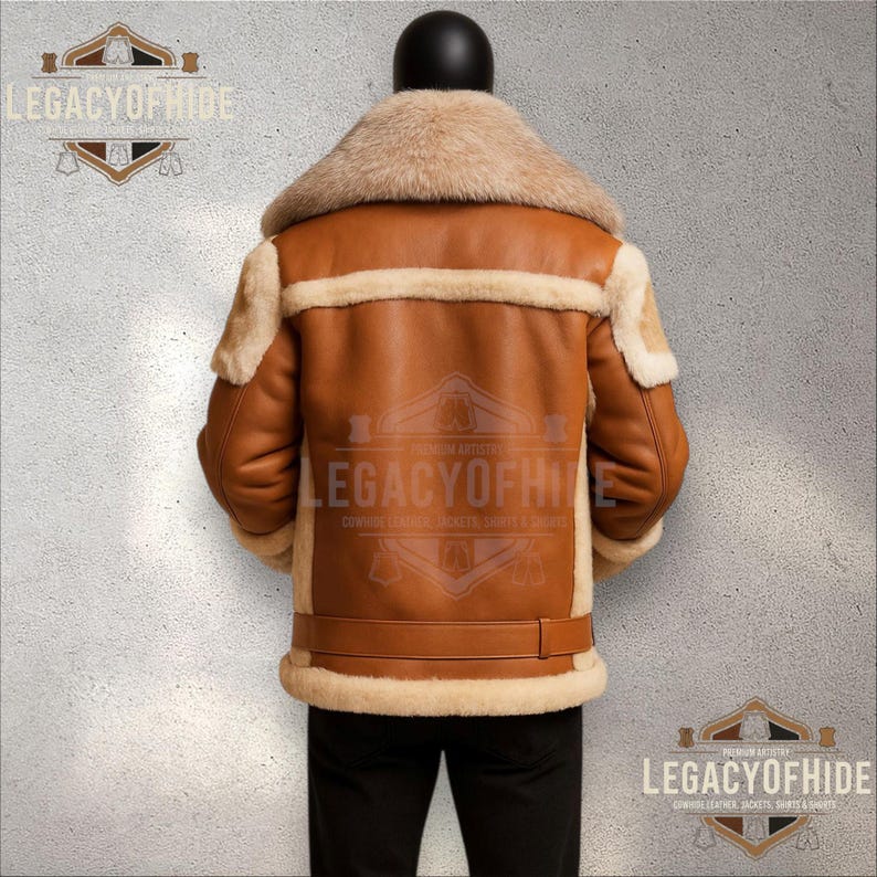 May include: A brown leather jacket with a beige shearling collar and trim. The jacket has a buckle detail at the waist and the text "LEGACYOFHIDE" is visible. The jacket is displayed on a mannequin.