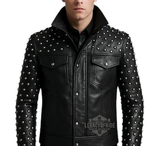 May include: Black leather jacket with silver stud detailing. The jacket features a classic collar, two chest pockets, and a button-up front. The Legacy of Hide logo is visible.