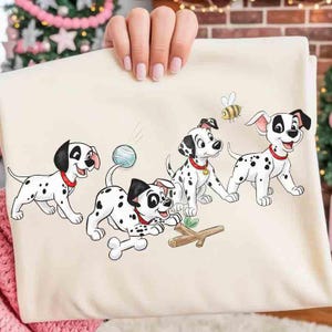 May include: A cream-colored fabric featuring a playful cartoon illustration of four Dalmatian puppies. The puppies are white with black spots, red collars, and are interacting with a ball, a stick, and a bee. The design is whimsical and suitable for children's items.