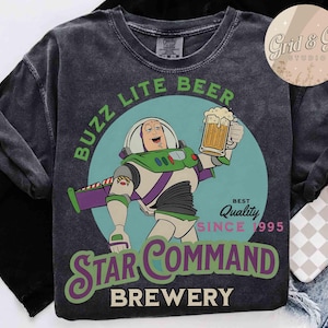 May include: Dark gray t-shirt featuring a cartoon of Buzz Lightyear holding a beer mug. The shirt includes the text "Buzz Lite Beer" and "Star Command Brewery" with "Best Quality Since 1995".