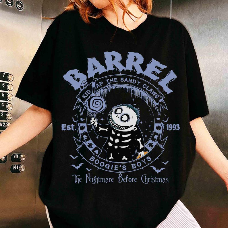 K&ouml;nnte beinhalten: Schwarzes T-Shirt mit einem Cartoon-Charakter aus "The Nightmare Before Christmas." Das Design enth&auml;lt die Schriftz&uuml;ge "BARREL", "BOOGIE'S BOYS" und "1993". Die Figur h&auml;lt einen Lolli. Das Shirt hat einen Rundhalsausschnitt.