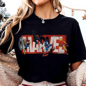 Puede incluir: Camiseta negra con el logo de Marvel en rojo y blanco, con ilustraciones de Thor, Black Panther, Capit&aacute;n Am&eacute;rica e Iron Man. El dise&ntilde;o es de estilo c&oacute;mic vintage.