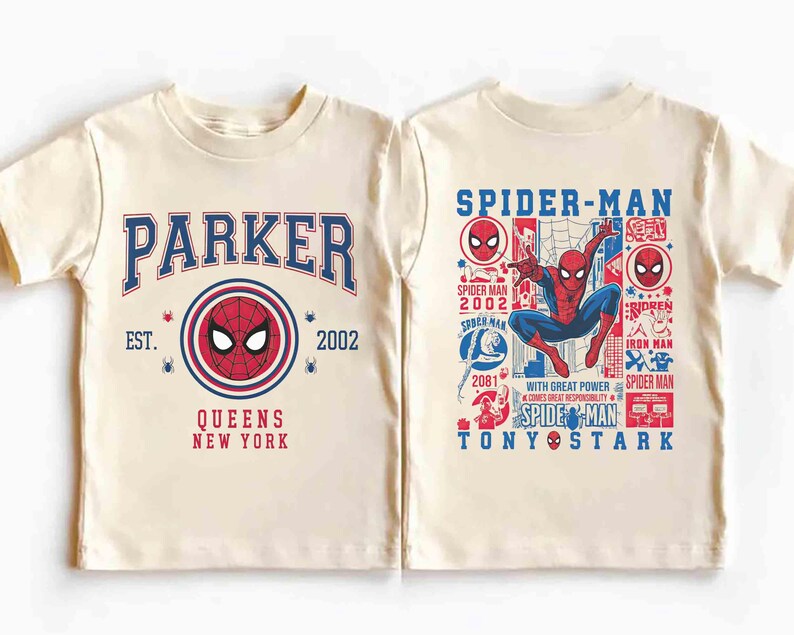 K&ouml;nnte beinhalten: Cremefarbenes T-Shirt mit Spider-Man-Design. Die Vorderseite zeigt "PARKER" in Blau, ein Spider-Man-Emblem und "QUEENS NEW YORK". Die R&uuml;ckseite zeigt Spider-Man in Aktion, mit Text wie "SPIDER-MAN" und "TONY STARK".