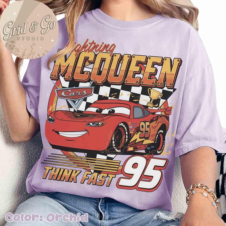 Pu&ograve; includere: T-shirt color orchidea con grafica di Saetta McQueen del film Cars. Il design include il testo "Lightning McQueen", "Cars", "Think Fast" e il numero "95". La maglietta ha una vestibilit&agrave; ampia.