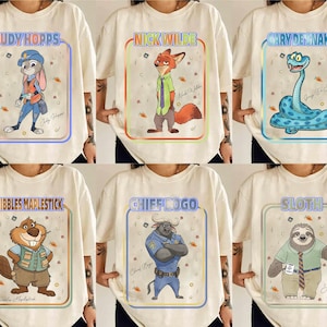 Puede incluir: Camisetas color crema con personajes de Zootopia. Cada camiseta muestra una ilustraci&oacute;n diferente de un personaje dentro de un marco colorido, incluyendo a Judy Hopps, Nick Wilde y Gary la Serpiente. Los nombres de los personajes est&aacute;n impresos encima de las ilustraciones.