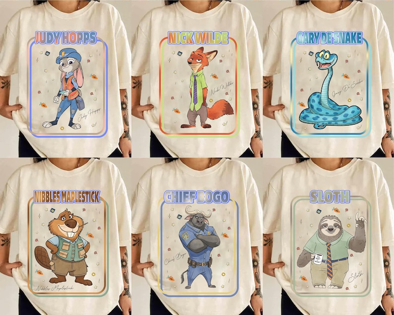 Puede incluir: Camisetas color crema con personajes de Zootopia. Cada camiseta muestra una ilustraci&oacute;n diferente de un personaje dentro de un marco colorido, incluyendo a Judy Hopps, Nick Wilde y Gary la Serpiente. Los nombres de los personajes est&aacute;n impresos encima de las ilustraciones.