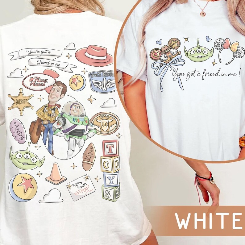 Op de afbeelding: Wit T-shirt met een kleurrijk grafisch ontwerp met personages en tekst uit de film "Toy Story". Het ontwerp bevat Woody, Buzz Lightyear en de zin "You've got a friend in me!"