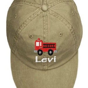 May include: A khaki baseball cap with an embroidered red fire truck and the name "Levi" in white.