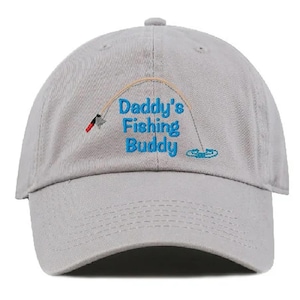 May include: A gray baseball cap with an embroidered design that says "Daddy's Fishing Buddy" with a fishing rod and a fish.