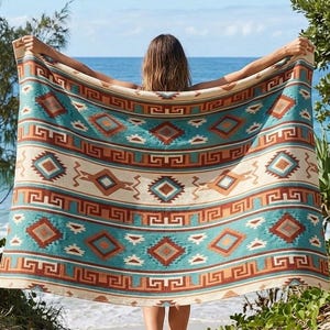 May include: A large rectangular beach towel featuring a repeating geometric pattern in shades of turquoise, cream, rust orange, and dark brown. The design includes diamond shapes, horizontal stripes, and a Greek key border motif throughout.
