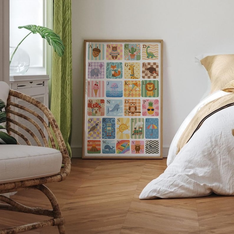 May include: A framed alphabet poster with colorful illustrations of animals and objects, each representing a letter. The artwork features a wooden frame and is displayed in a room with a bed and a wicker chair.