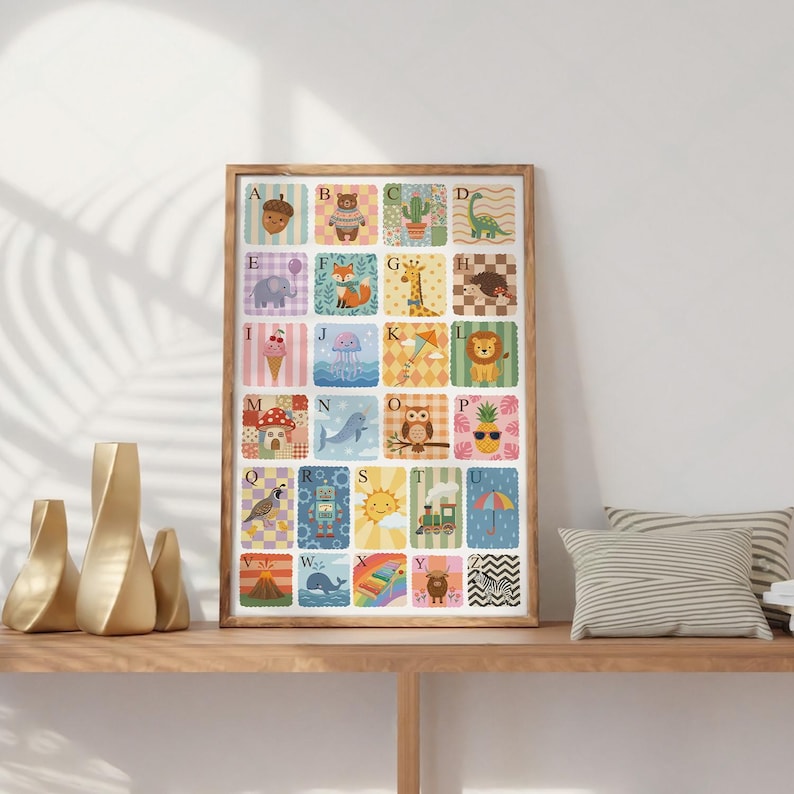 May include: A framed alphabet poster featuring colorful illustrations of animals and objects, each paired with a letter. The artwork includes an acorn, bear, cactus, dinosaur, elephant, fox, giraffe, hedgehog, ice cream, jellyfish, kite, and lion.
