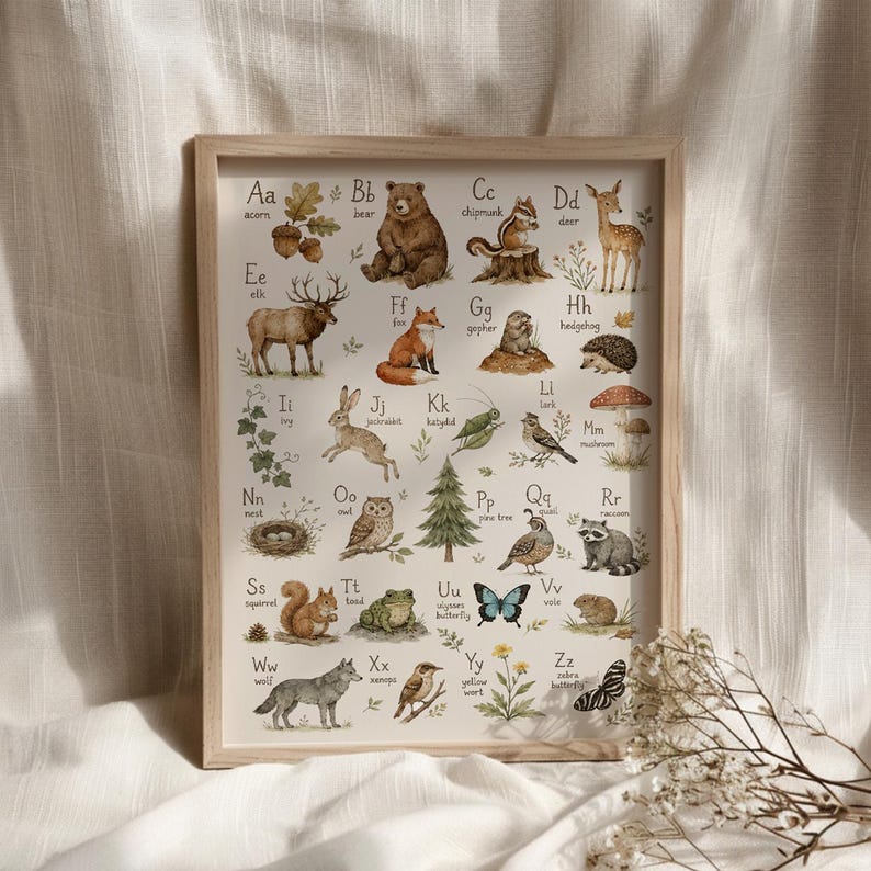 May include: A framed educational alphabet poster featuring watercolor illustrations of woodland animals and nature elements from A to Z, including a bear, deer, fox, and owl, with each letter paired with its corresponding name in black text.