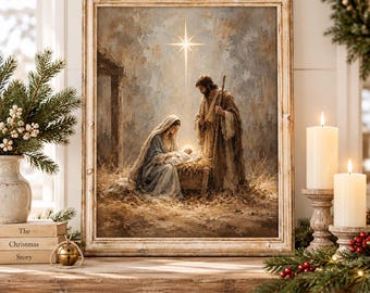 May include: A framed wall art print depicting a nativity scene with a person in a blue robe kneeling beside a wooden manger, a person in a brown robe standing nearby, and a bright star shining above, all set within a rustic, straw-filled stable.