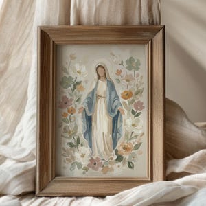 May include: A framed watercolor painting of a figure in a white dress and blue cloak, surrounded by flowers in soft pastel colors. The artwork is set in a natural wood frame, creating a serene and artistic aesthetic.