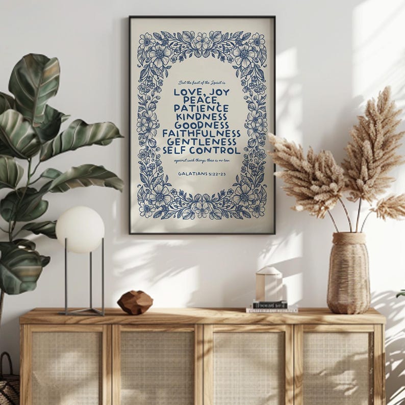 May include: A framed print with a floral border in blue, featuring the words "LOVE, JOY, PEACE, PATIENCE, KINDNESS, GOODNESS, FAITHFULNESS, GENTLENESS, SELF CONTROL" in a serif font. The text is from Galatians 5:22-23.