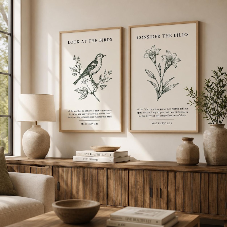 May include: Two framed wall art prints with cream backgrounds and black ink illustrations. The left print features a bird on a branch with the text LOOK AT THE BIRDS and Matthew 6:26. The right print shows lilies with the text CONSIDER THE LILIES and Matthew 6:28.