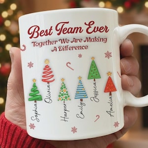 May include: White ceramic mug with the text "Best Team Ever" and "Together We Are Making A Difference". The mug features Christmas tree designs with names: Sophia, Olivia, Harper, Emily, Jessica, and Amelia. Includes snowflakes and candy cane accents.
