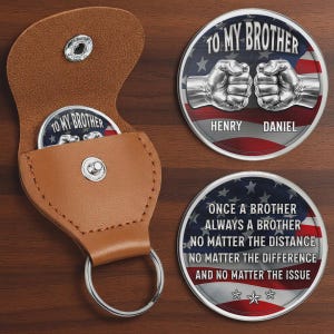 May include: A brown leather keychain case with a silver snap closure, holding a round coin. The coin has an American flag design with the text "TO MY BROTHER" and two fists. Another coin has the text "ONCE A BROTHER ALWAYS A BROTHER".