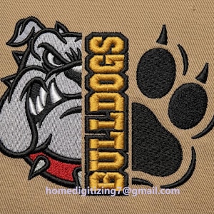 May include: An embroidered design on tan fabric featuring the left half of a grey bulldog face with a red collar, a vertical yellow banner with the text BULLDOGS in black, and a large black paw print on the right side with the email address below.