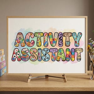 May include: A framed print with the words "ACTIVITY ASSISTANT" in colorful bubble letters. Each letter is filled with various themed illustrations, including puzzles, musical notes, and game pieces. The print is displayed on a wooden easel.