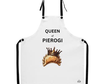 May include: White apron with black straps and trim, featuring the text "QUEEN of PIEROGI" above an illustration of a pierogi wearing a crown. The apron has a small mountain graphic at the bottom.