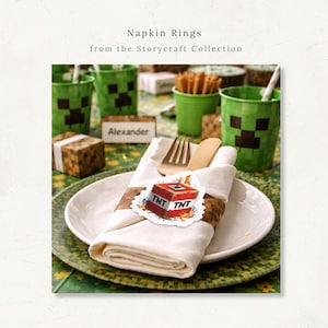 May include: A table setting with white napkins, wooden cutlery, and a TNT-themed napkin ring. Green cups with pixelated faces and the text "Napkin Rings from the Storycraft Collection" are also visible. A name card reads "Alexander".