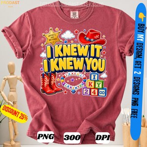 May include: A dusty rose t-shirt featuring a graphic print with a gold sheriff star, a red cowboy hat, red cowboy boots, a colorful beaded necklace, and alphabet blocks. The text reads I KNEW IT I KNEW YOU. The design includes small white clouds and stars.