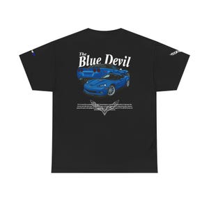 May include: Black t-shirt featuring two blue sports cars with the text "The Blue Devil" in white. Below the cars is a white graphic and text. The shirt is made of a soft, comfortable material.
