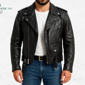 Könnte beinhalten: Schwarze Leder-Motorradjacke mit asymmetrischem Reißverschluss, mehreren Taschen und einem Gürtel in der Taille. Die Jacke hat silberfarbene Hardware und ein fallendes Revers. Das Logo "AMERICAN JACKETS" befindet sich oben links.