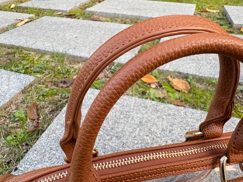 Detailed view of double top handles on a brown-trim clear PVC stadium bag.