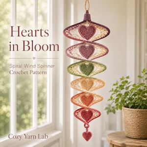 Puede incluir: Una decoración de ganchillo en espiral vertical con seis motivos de corazón graduados en tonos morado, verde, naranja y rojo. El texto dice: Hearts in Bloom, Spiral Wind Spinner Crochet Pattern, Cozy Yarn Lab.