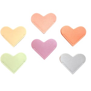 May include: Six heart-shaped leather patches in pastel colors: peach, orange, yellow, green, pink, and silver. Each heart is stitched around the edges with white thread. The patches are arranged on a white background.