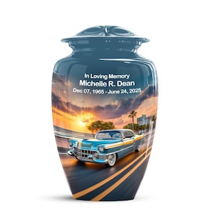 May include: A blue cremation urn with a glossy finish. The urn features a scenic image of a classic blue car driving on a road at sunset. Text on the urn reads "In Loving Memory Michelle R. Dean Dec 07, 1965 - June 24, 2025."
