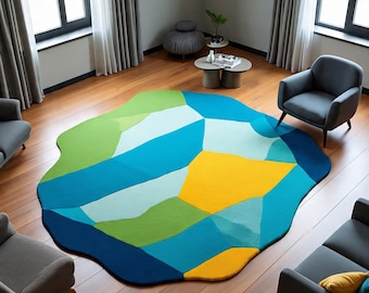 May include: A colorful, abstract area rug with a unique, organic shape. The rug features geometric patterns in shades of green, blue, and yellow. The rug is placed on a hardwood floor in a living room setting.