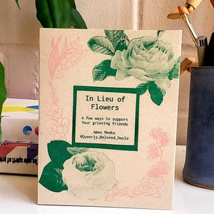 Puede incluir: Una tarjeta rectangular con el texto "In Lieu of Flowers" en un recuadro verde, con ilustraciones florales en verde y rosa. La tarjeta también incluye el texto "A few ways to support your grieving friends" y el nombre "Ames Meeks".