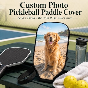 May include: A custom pickleball paddle cover featuring a printed photograph of a golden retriever sitting on a sandy beach. The cover has a black border, a zipper, and a black wrist strap. Text on the image reads: Custom Photo Pickleball Paddle Cover — Send 1 Photo • We Print It On Your Cover —.